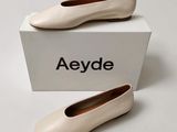 a pair of white shoes sitting on top of a white box