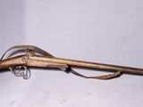 an old rifle with a wooden barrel and a green case