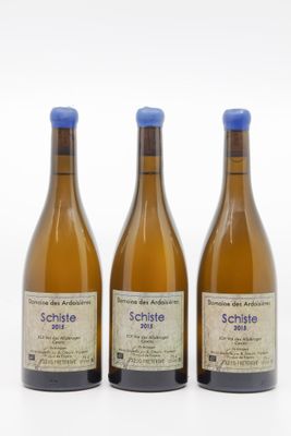 trois bouteilles de vin posées les unes à côté des autres sur une surface blanche