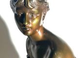 a bronze statue of a boy sitting on top of a book