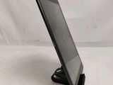 the tablet is sitting on top of the stand on the table