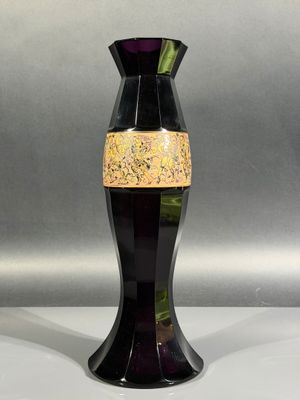 a black vase with a gold stripe on it