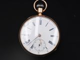 a gold pocket watch with roman numerals on it