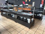 sol carrelé dans un restaurant où se trouve une longue table de buffet sur laquelle sont disposées des assiettes et des bols
