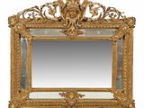 un miroir sculpté avec un cadre doré sur fond blanc