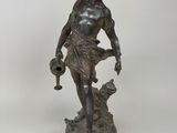 an antique bronze statue of a woman holding a jug