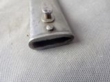 a metal object that is laying on a white surface