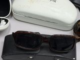 several pairs of sunglasses are sitting on a table next to a pair of glasses