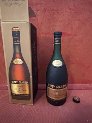 une bouteille de cognac à côté d'un carton de vin