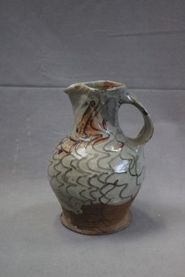 a white and brown vase sitting on a table