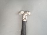 a close up of a walking stick with a metal handle