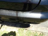 a close up of a car ' s rear bumper with a cat on it
