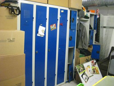 un casier bleu au milieu d'une pièce où se trouvent des cartons par terre