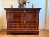 une commode en bois surmontée d'une statue