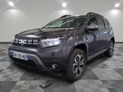 une photo d'une dacia grise garée sur un sol en damier
