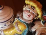 a figurine of a woman holding a pot and a bird