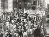 black and white photograph of a large crowd of people on a city street