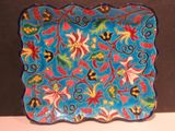 une assiette bleue ornée de fleurs colorées, posée sur une table