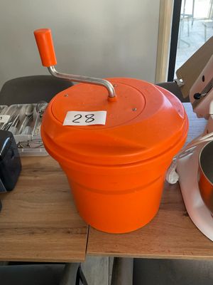 un seau orange muni d'une poignée, posé sur une table en bois