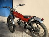 a red motorcycle parked on the sidewalk in front of a building
