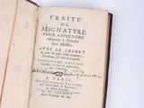 a book open on a table with two other books on the table