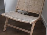 a chair that is sitting in a room with a plant in it
