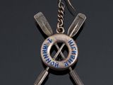 an image of a metal keychain with two crossed knives on it