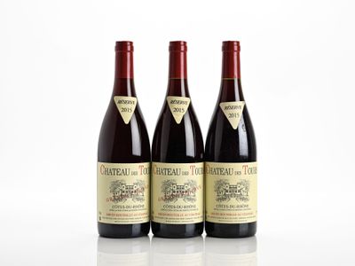 three bottles of red wine sitting next to each other on a white surface
