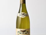 une bouteille de vin blanc posée sur une table en bois