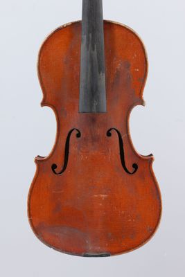 an old violin sitting on top of a white surface