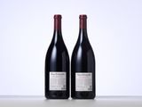 two bottles of red wine sitting next to each other on a table