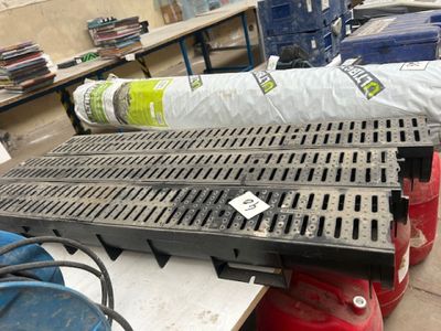 une grille métallique posée au sol, à côté d'une borne d'incendie rouge