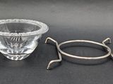 a glass bowl and a metal holder on a table