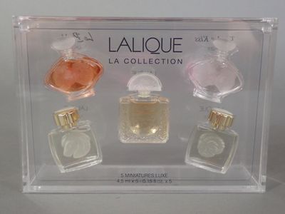 four bottles of perfume in a clear display case