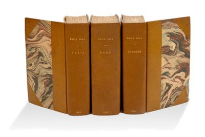 trois livres sont empilés sur une surface blanche