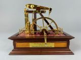 a miniature model of a steam engine on a wooden base