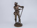 a bronze statue of a man with a cane and hat