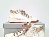 white sneakers with brown laces on them sitting on top of a box