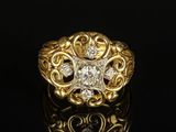 a close up of a gold and diamond ring on a black surface