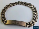 un gros plan sur un bracelet en métal sur lequel figure un nom