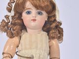 a doll that is wearing a dress and a headband