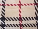 a close up of a checkered fabric with a red and black stripe