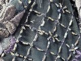 a close up of a purse with a purple and black design on it
