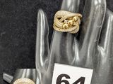 deux bagues en or sur la main d'un mannequin, sur laquelle figure le chiffre 64