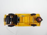 a yellow toy truck with black wheels on a white surface