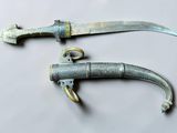 pair of old and rusty knifes on a white surface