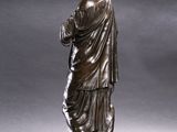 bronze statue of a man standing on a pedestal with his hands folded