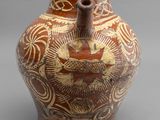 un vase marron orné d'un motif sur un fond gris