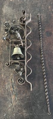 une photo d'un morceau de métal sur lequel est fixée une cloche