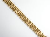a close up of a gold bracelet on a white surface